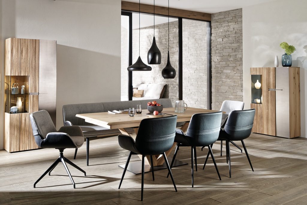 Esszimmer mit Holztisch, Polsterstühlen und Vitrinenschränken, modern eingerichtet.