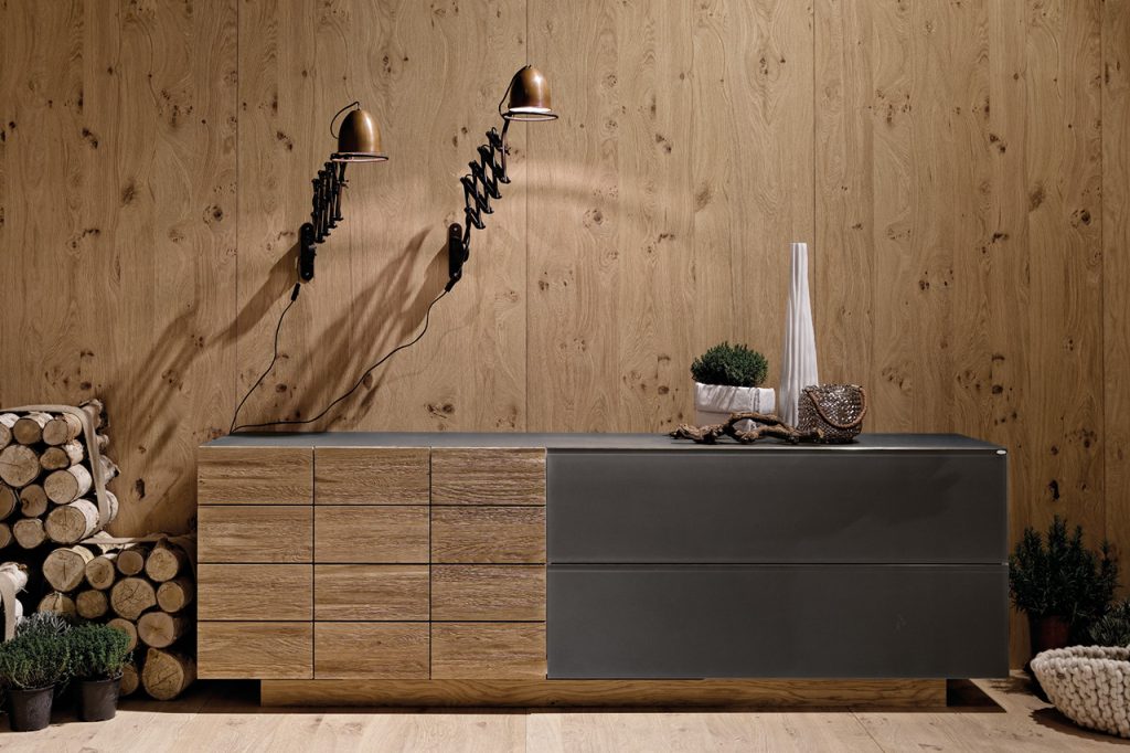 Sideboard aus Holz und Metall vor Holzvertäfelung, dekorativ inszeniert.
