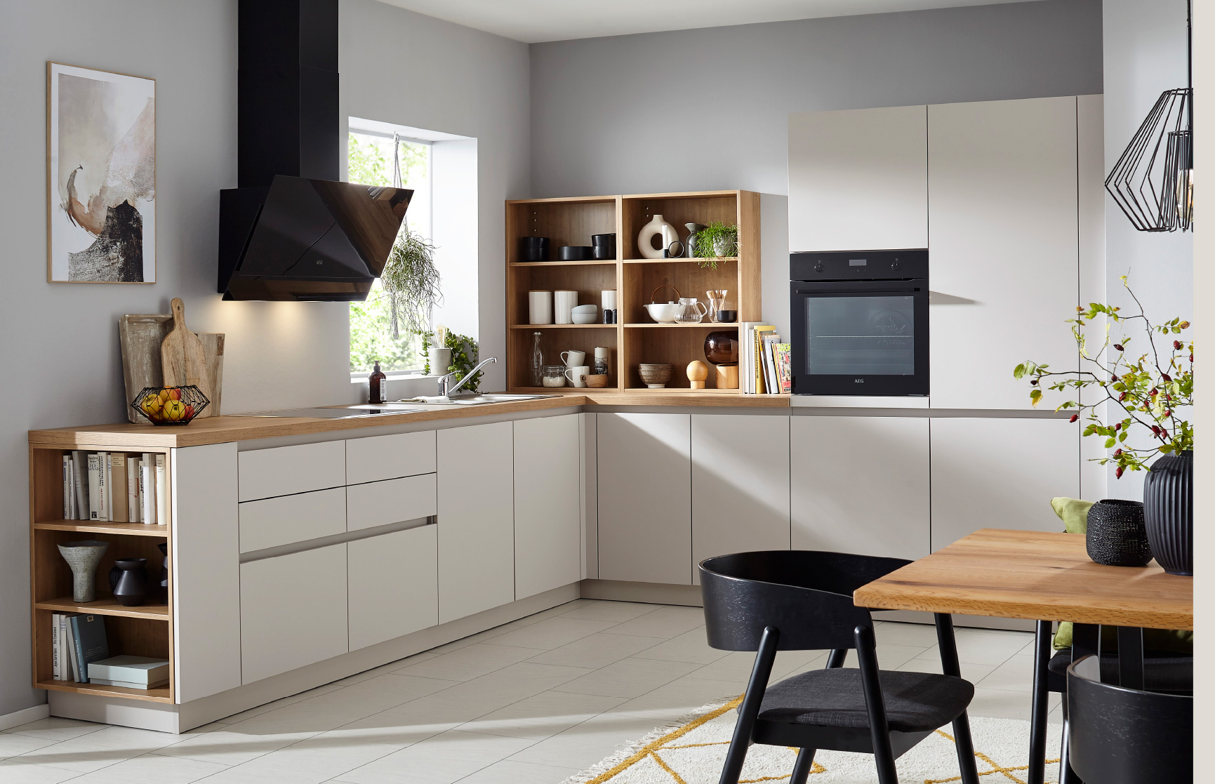 L-förmige Küche mit hellen Fronten, Holzarbeitsplatte und offenen Regalen, Fenster links und Esstisch vorne