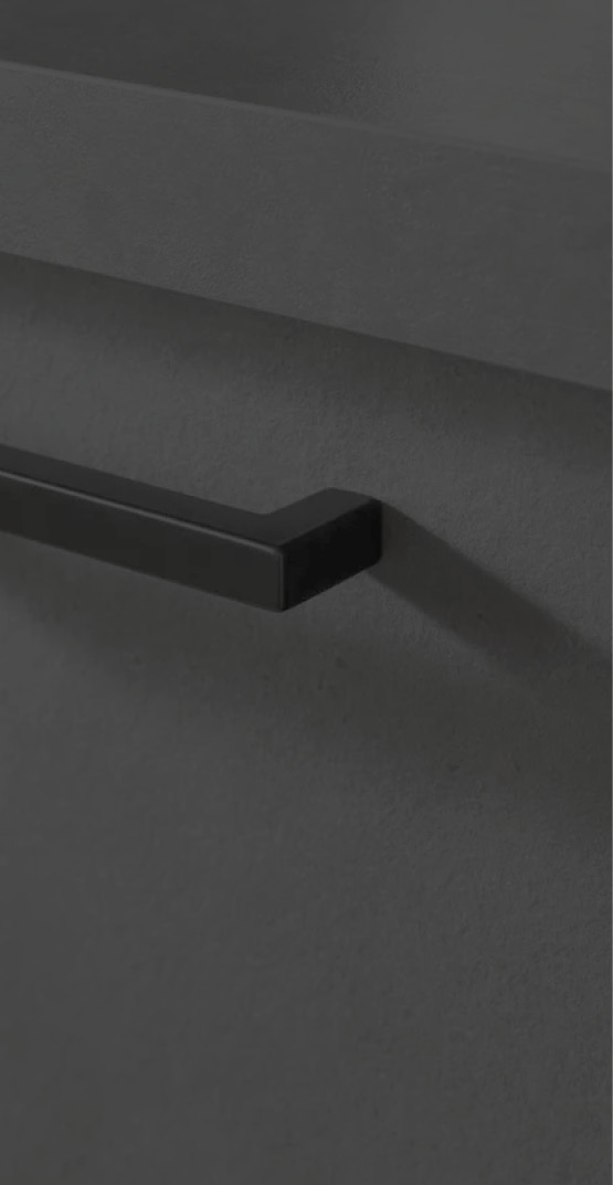 Nahaufnahme eines schwarzen Metallgriffs an grauer Küchenfront mit glatter Oberfläche