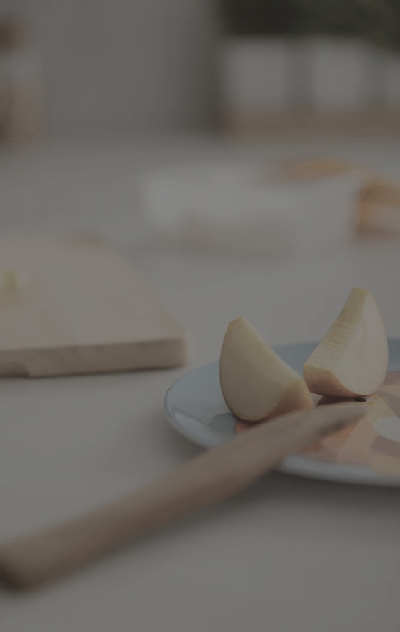 Schriftzug global Küchen oben rechts, Apfelstücke auf Teller und Messer auf Arbeitsplatte