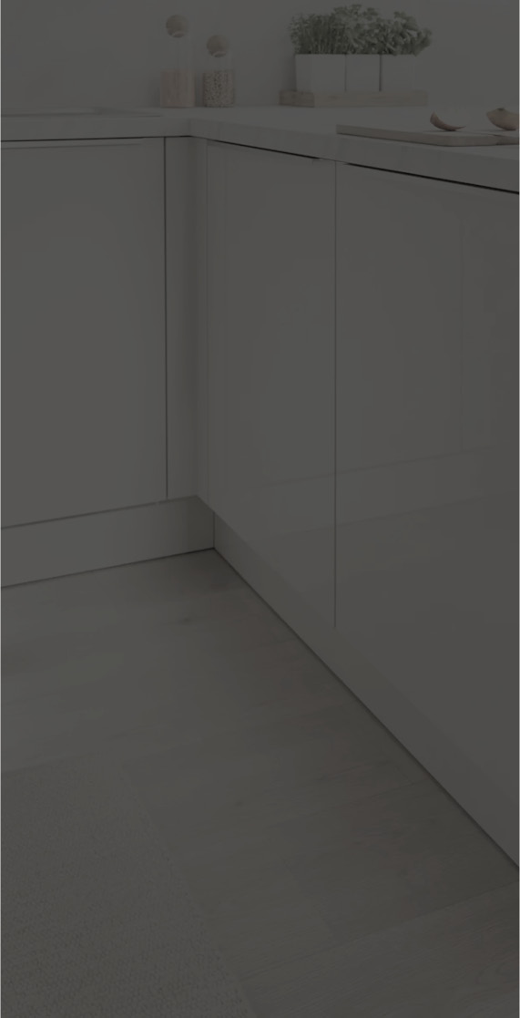 Eckbereich einer weißen Küche mit grifflosen Fronten und heller Arbeitsplatte