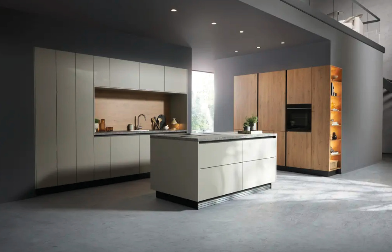 Küche mit heller Insel mittig, Küchenzeile links und Holz Hochschränken rechts mit offenem beleuchtetem Regal