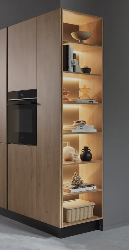 Holz Hochschrank mit Backofen links und offenem Regal rechts mit Büchern, Vasen und Beleuchtung