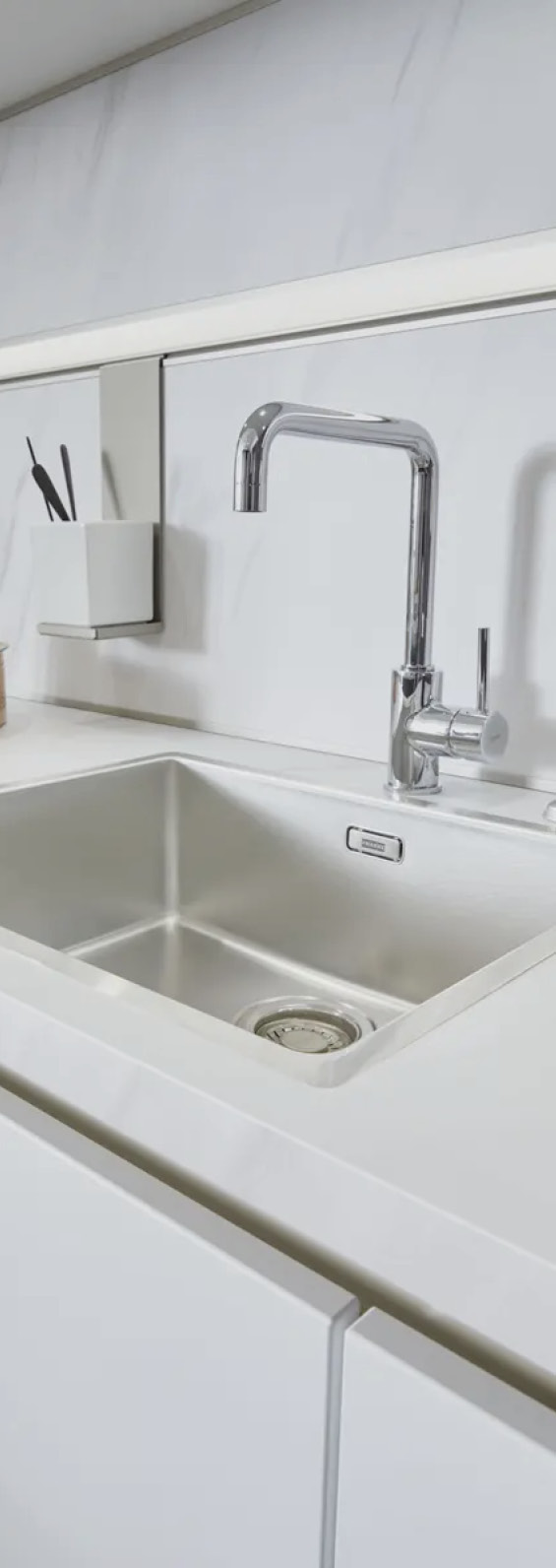 Schriftzug contur MODERN KITCHEN DESIGN oben, darunter Spüle mit Armatur und weißer Arbeitsfläche