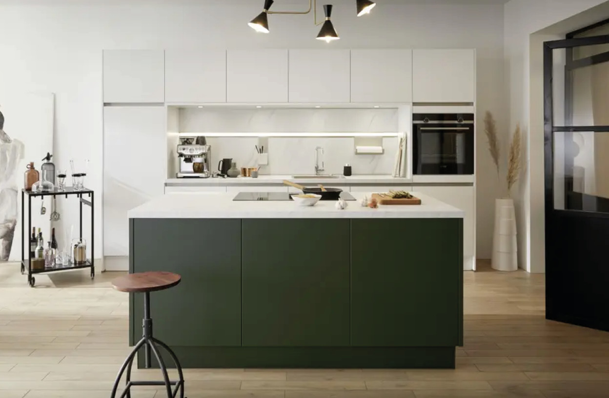 Küche mit grüner Insel vorne, weißen Schränken hinten und Regalwagen links im Raum