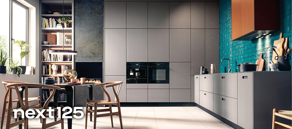 Helle Einbauküche mit grünen Unterschränken, weißer Hochschrankwand und moderner Wandgestaltung mit Pflanzenmodulen. Zeitgemäße next125 Küche mit klarer Linienführung.