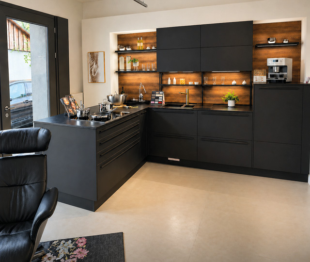 Moderne schwarze Einbauküche mit Kochinsel im Küchenabverkauf