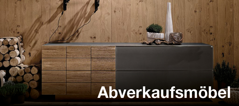Sideboard vor Holzwand Dunkles Sideboard vor Holzwand mit zwei Wandleuchten und Text Abverkaufsküchen
