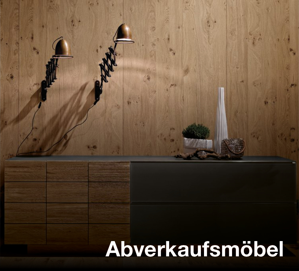 Sideboard vor Holzwand Dunkles Sideboard vor Holzwand mit zwei Wandleuchten und Text Abverkaufsküchen